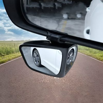 Front-view car side mirror with vehicle reflection on a rural road during daytime, showcasing automotive, driving, and transportation concepts.