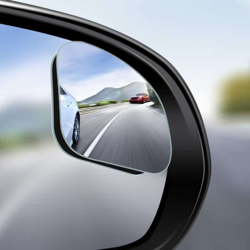 High-quality car side mirror showing vehicles on a scenic mountain road, emphasizing driving safety and vehicle visibility.