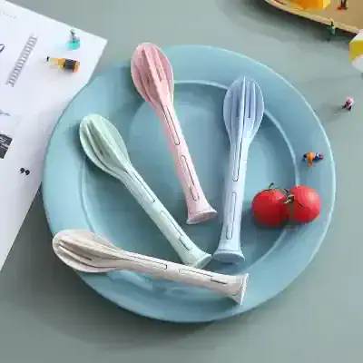 Colorful silicone spoon utensils on pastel blue plate, with tomatoes and tiny figurines, ideal for modern kitchen decor and cooking accessories, perfect for everyday use or gift-giving.