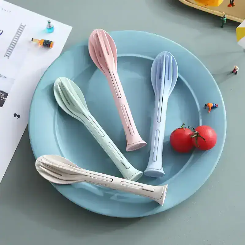 Colorful silicone spoon utensils on pastel blue plate, with tomatoes and tiny figurines, ideal for modern kitchen decor and cooking accessories, perfect for everyday use or gift-giving.