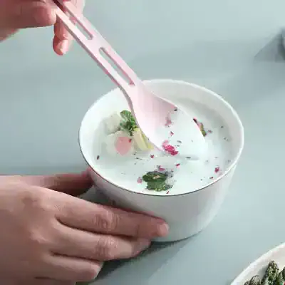 Creamy yogurt with edible flowers and fresh mint in a white bowl at Monalisa Store, showcasing healthy, organic, and stylish desserts ideal for health-conscious customers.