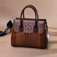 Luxury leather handbag with crocodile pattern and logo detail for women.