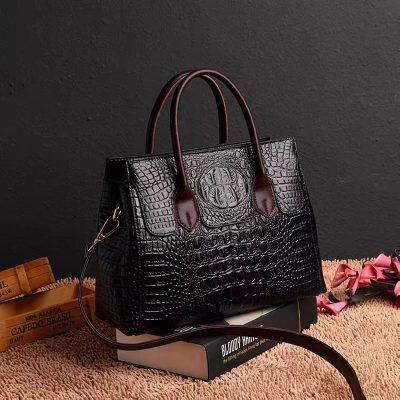 Luxurious black crocodile leather handbag with brown handles, stylish and elegant accessory for women. Perfect for fashion-forward individuals seeking premium quality designer bags.