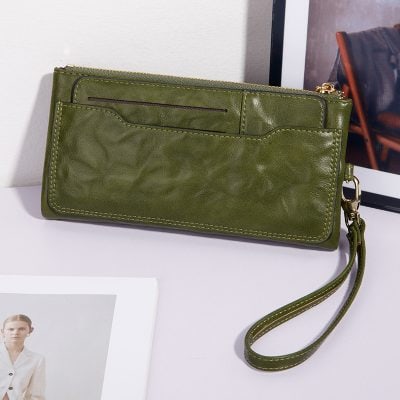 Green leather wristlet wallet with zip closure, card slots, and detachable strap, perfect for stylish women on the go. Ideal for daily use and travel accessories.