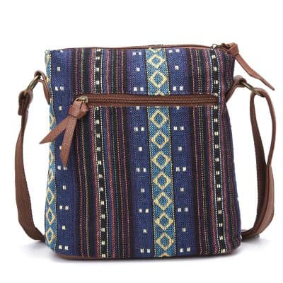 Blue ethnic patterned crossbody bag with brown leather accents and zipper pocket.