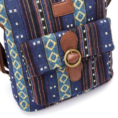 Decorative woven backpack with leather accents and gold hardware, ideal for travel and everyday use, featuring vibrant blue, yellow, and red geometric patterns.