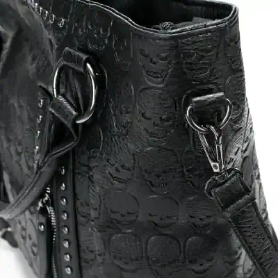 Black leather handbag with skull embossed pattern, metal hardware, and detachable strap for versatile styling and edgy fashion statement.