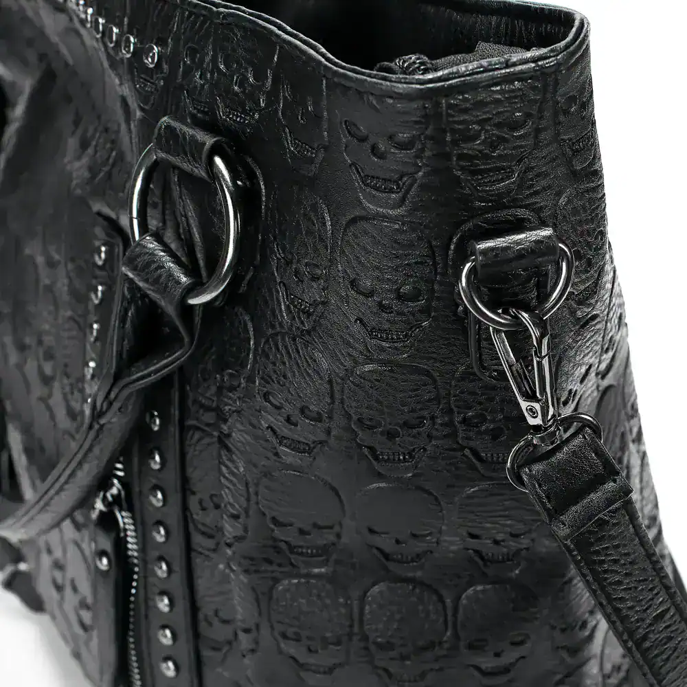 Black leather handbag with skull embossed pattern, metal hardware, and detachable strap for versatile styling and edgy fashion statement.