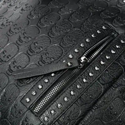 High-quality black textured leather bag with skull motifs and metal studs, featuring a sturdy zipper detail. Perfect for fashion-forward accessories and gothic-inspired style.
