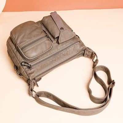 Messenger bag with multiple zippered compartments, made of durable material, ideal for travel and daily use. Stylish accessory for carrying essentials conveniently.