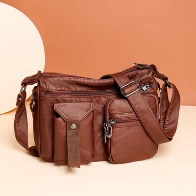 Leather messenger bag with multiple zippered compartments and adjustable strap, perfect for carrying personal items and accessories. Stylish and functional for everyday use.