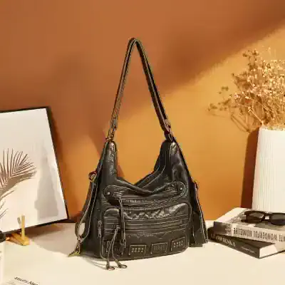 Black leather fashion handbag with multiple zippered compartments and decorative details, ideal for everyday use and stylish accessories.
