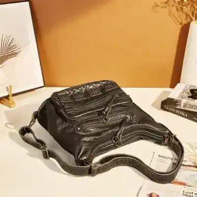 Black leather handbag with multiple zippers, stylish design, and adjustable strap, ideal for fashion-conscious women seeking high-quality accessories. Perfect for daily and casual use.