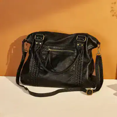 Genuine black leather handbag with gold zipper and adjustable strap, perfect for fashionable accessories and everyday use.