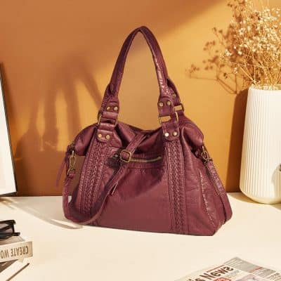 Luxurious burgundy leather handbag with braided details and gold hardware, ideal for fashion-forward women seeking stylish and versatile accessories. Perfect for everyday use or special occasions.