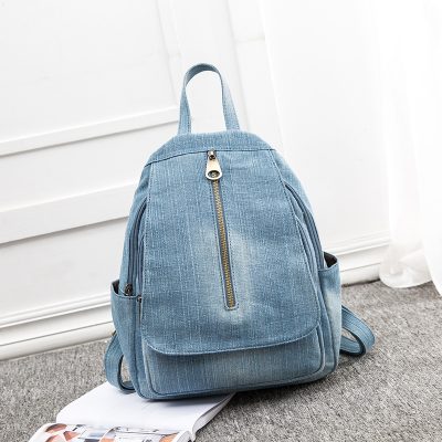 Blue denim backpack with zipper closure and side pockets, ideal for daily use or travel, stylish and functional accessory for students and professionals.