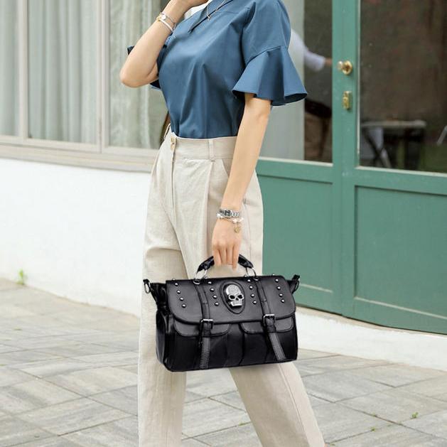 Stylish woman holding a black skull-embellished handbag outside Monalisa Store, showcasing trendy accessories and fashion essentials for a modern, chic look.