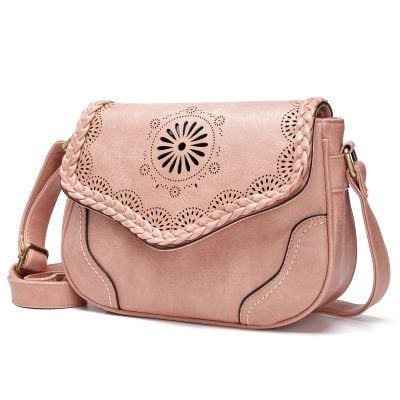 Elegant pink leather handbag with intricate laser-cut floral design, braided trim, and adjustable strap, perfect for stylish women seeking a versatile accessory.