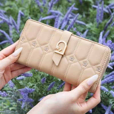 Elegant beige designer wallet with quilted pattern and decorative buckle, perfect for luxury accessories and fashion statement. Ideal for women seeking stylish, high-quality wallet options.