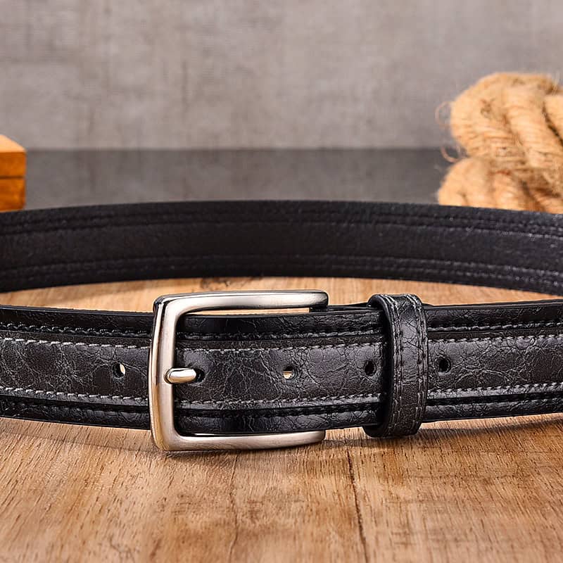 Stainless steel belt buckle on black leather belt for men and women.