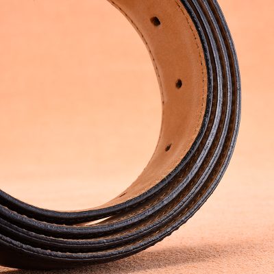 High-quality leather belt coiled on a wooden surface, showcasing premium craftsmanship for men's fashion accessories. Perfect for stylish, durable belts from Monalisa Store.