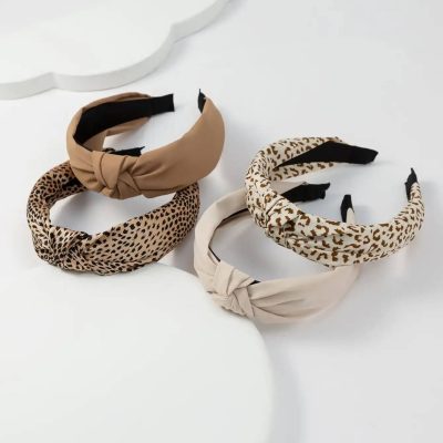 Soft, fashionable animal print and solid color headbands with knotted designs, perfect for women’s accessories and hair styling. Variety of trendy headbands featuring leopard patterns and neutral tones.