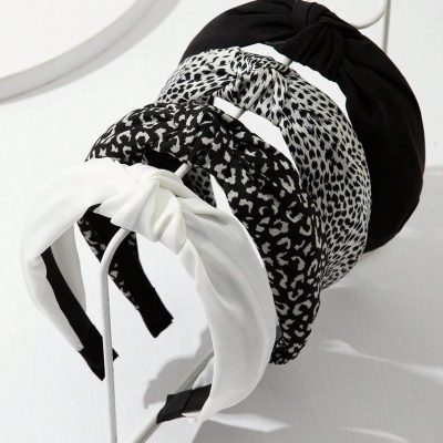 Black and white animal print headbands with bow details displayed on a white stand, perfect for stylish accessories and hair styling.