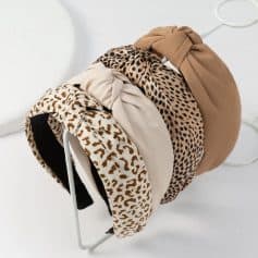 Stylish leopard print and neutral-colored headbands displayed on a white rack, perfect for fashionable accessory shopping at Monalisa Store.
