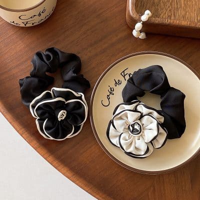 Silk hair scrunchies with floral design on Monalisa Store ceramic plate, black and white accessories, elegant hair accessories, fashion hair ties for women and girls, luxury hair adornments for styling.