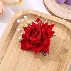 Red velvet rose hair clip with pearl accents, perfect for feminine style and special occasions. Elegant hair accessory featuring handcrafted fabric flower and pearl details, ideal for enhancing elegant look.