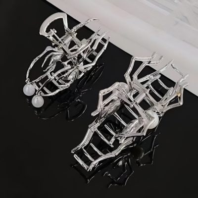 Polished silver jewelry skeletons with pearl accents displayed on a black surface, showcasing unique and modern accessory designs at Monalisa Store.