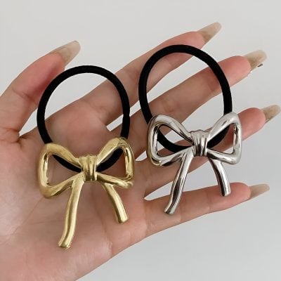 Elegant bow-shaped hair ties with gold and silver metallic finishes, featuring black elastic bands, perfect for stylish hair accessories and beauty fashion.