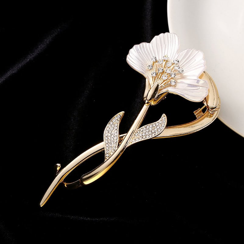 Golden floral brooch with pearl accents and rhinestones, elegant jewelry accessory for women.