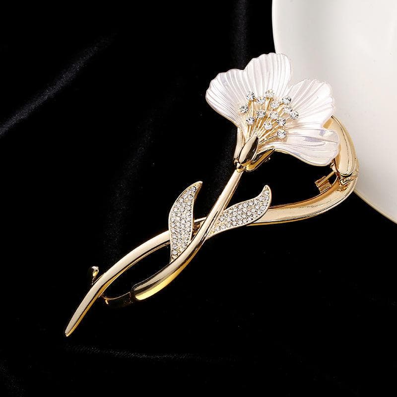 Elegant floral brooch jewelry with gold, white enamel petals, and sparkling crystals, perfect for fashion accessories and statement style.