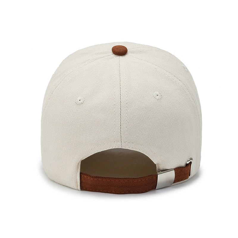 White baseball cap with adjustable strap, perfect for sports and casual wear, featuring a brown button and back closure.