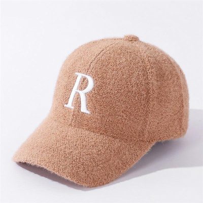 Soft peach-colored fleece baseball cap with white embroidered "R" logo, stylish and comfortable accessory ideal for casual wear and outdoor activities.