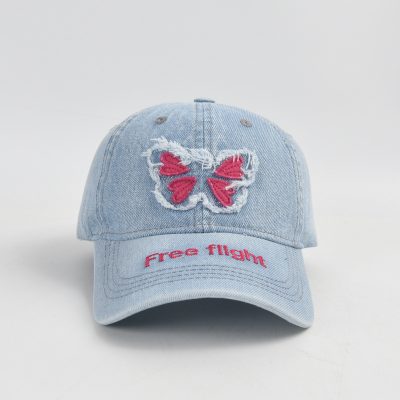 Pink butterfly embroidery on distressed denim baseball cap, "Free Flight" slogan, casual stylish accessory for spring and summer, perfect for outdoor activities and sunglasses.