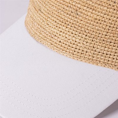 Straw fedora hat with woven straw crown and white fabric brim, stylish accessory for sun protection and fashion. Perfect for summer outings and outdoor events.