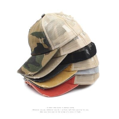 Casual camouflage and mesh baseball caps stacked, various styles for outdoor and casual wear, ideal for fashion accessories and sun protection.