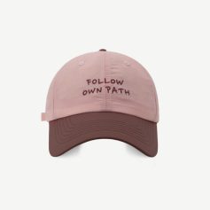 Follow own path embroidered baseball cap in soft pink and brown, adjustable strap, stylish accessory for casual or athletic wear, featuring motivational quote design.