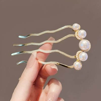 Elegant pearl hair clip with gold accents and sparkling rhinestones, perfect for stylish hair accessories and special occasions.