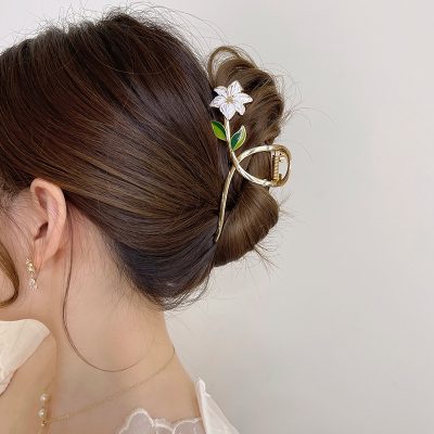 Silhouette of a woman with elegant brown hair styled in an updo with a custom hair accessory featuring a flower and gold buckle, ideal for fashionable and professional looks at Monalisa Medical Store.