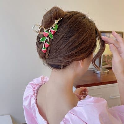 Hair updo with strawberry and leaf hair clip, elegant hairstyle accessory for women, suitable for special occasions or casual wear.