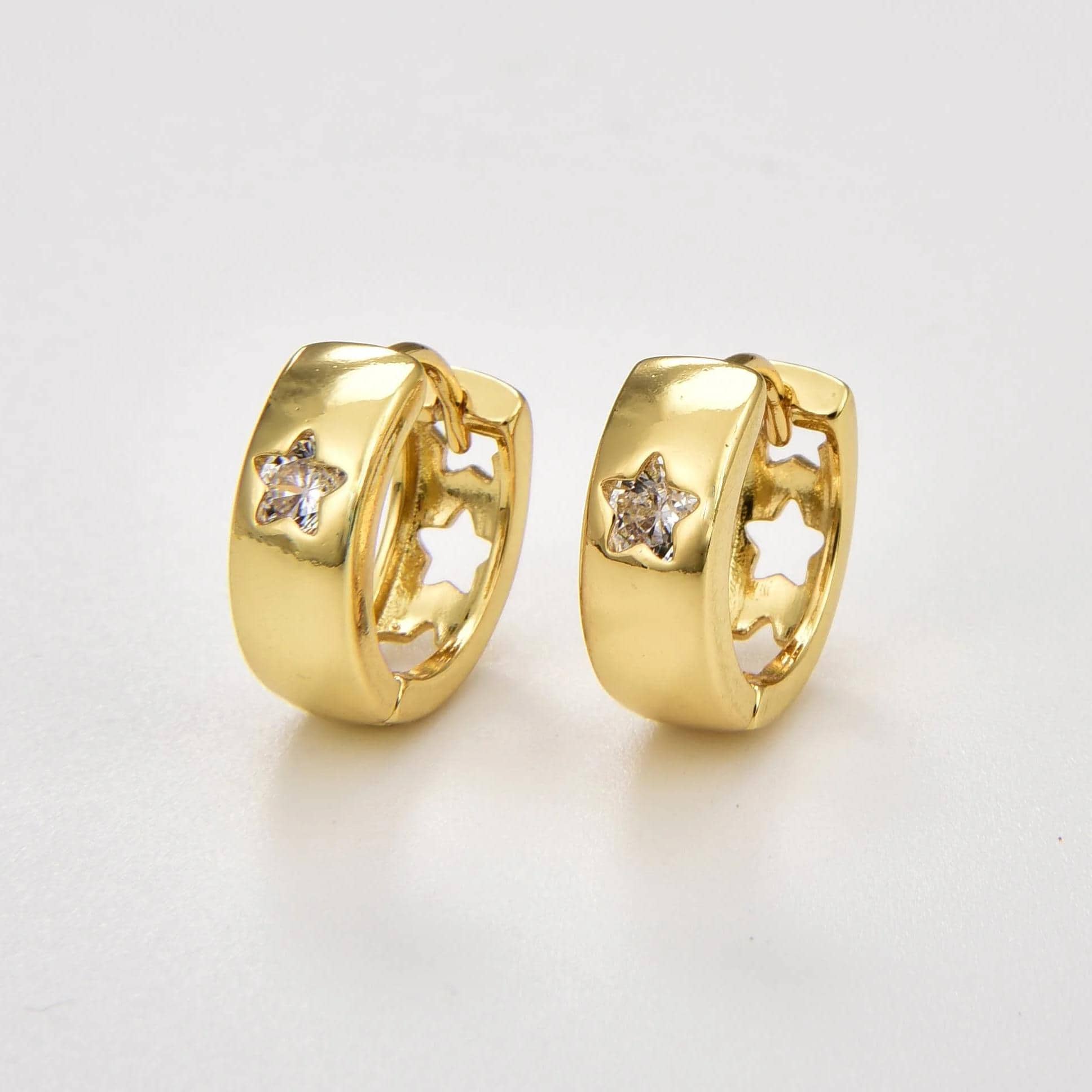 Shiny gold hoop earrings with star-shaped cutouts and embedded clear gemstones, perfect for stylish accessories. Crafted for elegance and everyday wear, these earrings add a touch of sparkle and fun to any outfit.