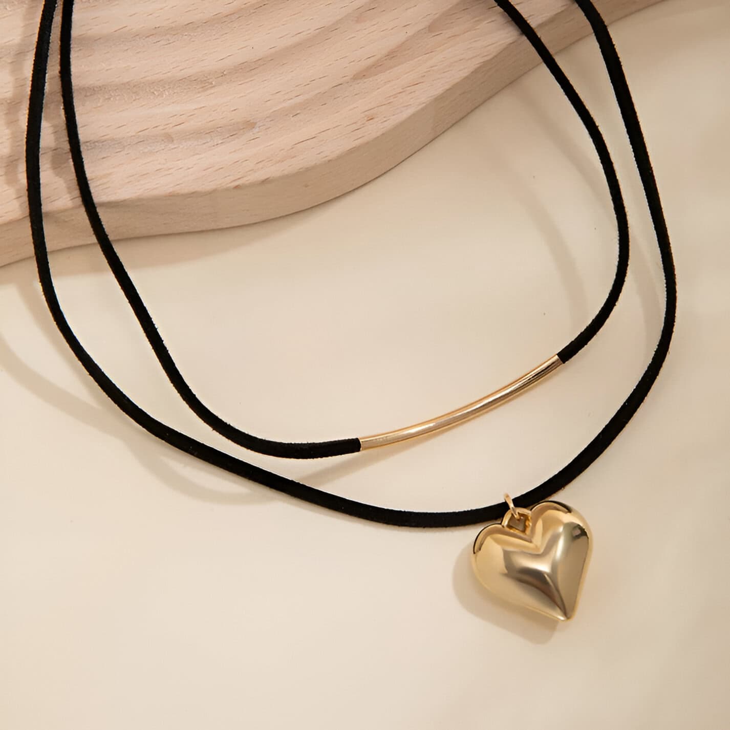 Gold heart pendant necklace on black cord, stylish jewelry accessory, perfect for casual and formal wear, available at Monalisa Store.