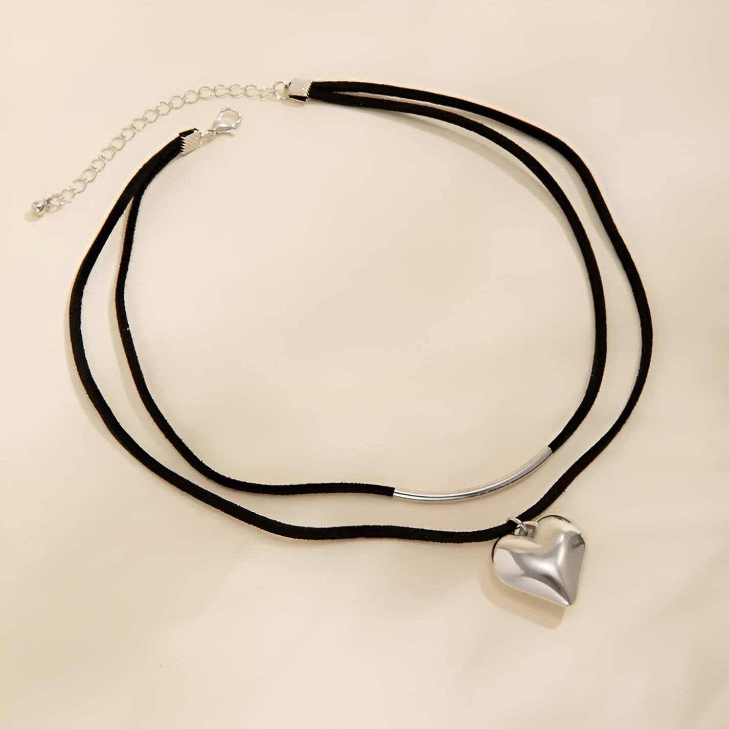 Black choker necklace with a silver heart pendant, stylish and trendy jewelry perfect for fashion accessories.