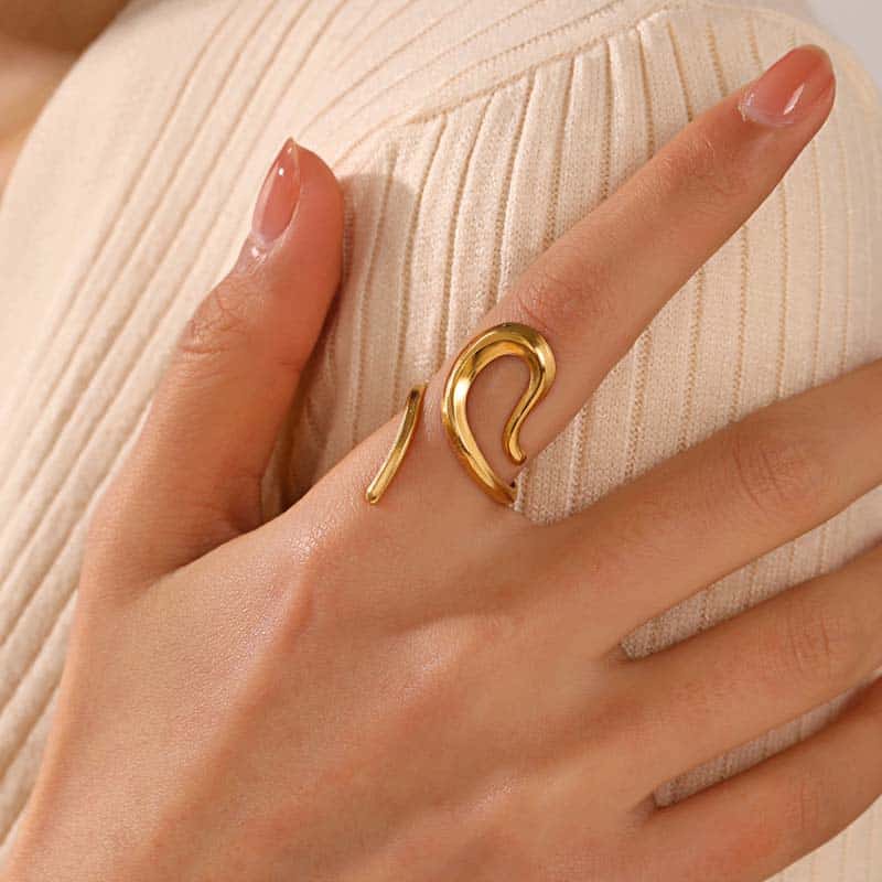 Elegant gold swirl ring showcased on a woman's finger, perfect for modern jewelry enthusiasts. Ideal for enhancing your jewelry collection with stylish accessories from Monalisa Store.