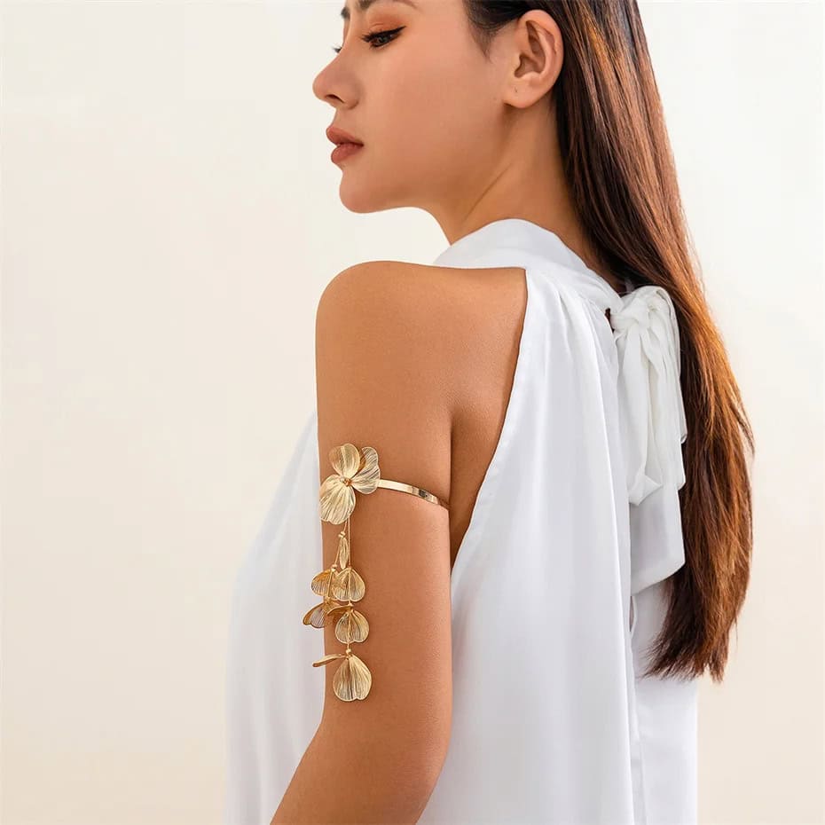 Elegant woman with gold floral arm cuff jewelry, showcasing stylish accessories for fashion-conscious individuals.