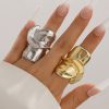 Shiny silver and gold statement rings on fingers, elegant jewelry fashion, Monalisa Medical Store, luxury accessories, modern jewelry design.