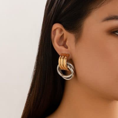 Gold and silver hoop earrings on a woman's ear, showcasing stylish jewelry options available at Monalisa Store for eye-catching accessories.